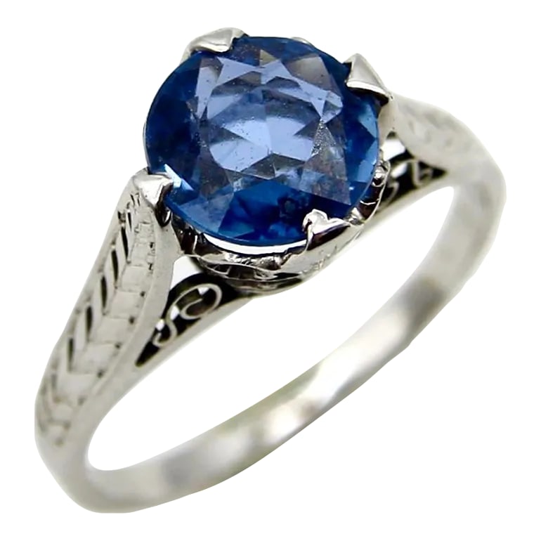 14k White Gold Art Deco Natural Blue Sapphire Filigree Ring Size 4.5: This is part of Chairish's Fine Jewelry assortment. This 14k white gold ring features a natural sapphire in an Art Deco mount. The sapphire is a gorgeous shade of medium blue with grayish undertones.
