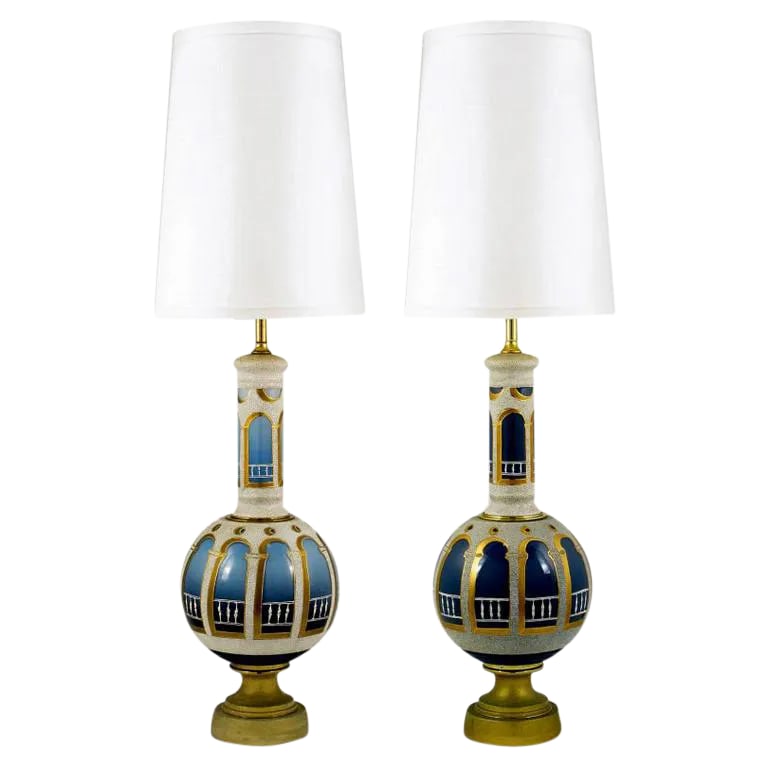 Reverse Painted & Gilded Blue Glass Table Lamps - a Pair: Hand painted and gilded table lamps, with patinated brass pedestal bases, and massive vase form bodies. Stand 52" high from base to finial. Romanesque columns and balustrade are executed in a stone-li