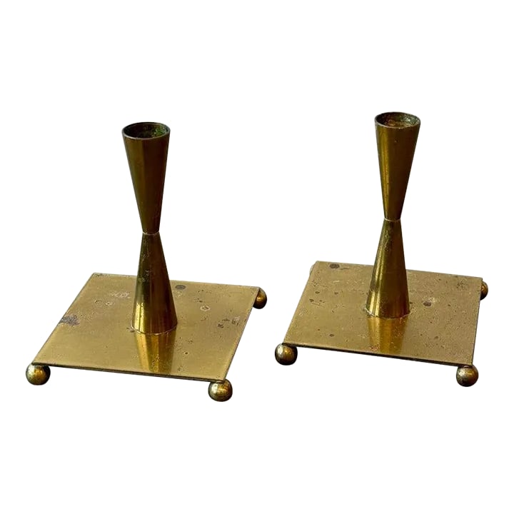 Vintage Brass Candleholders With Ball Foot Detail, Circa 1960s: Vintage Brass Candleholders With Ball Foot Detail, Circa 1960s. Biconic brass shaft with a wide square base mounted to four orb feet. Unlabeled. SPECS: 5" H | 4 1/4" Base Depth/Width | 3/4" Taper