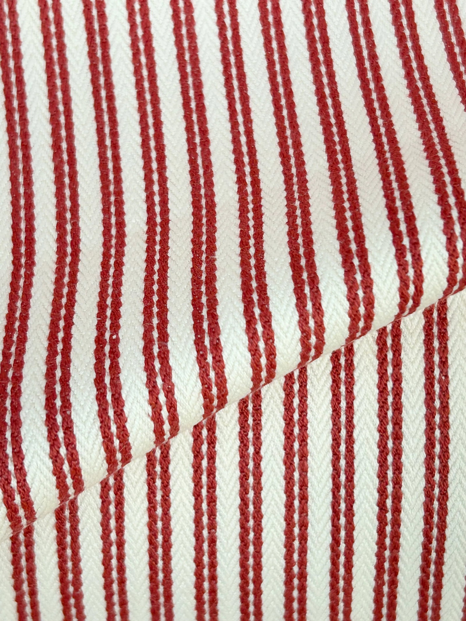 Jane Churchill "Gilpin" Ticking Stripe- 21.5 Yards: A red and white cotton ticking stripe with a tiny white herringbone pattern between the red warp stripes. The overall horizontal repeat is 5/16". The hand is lovely, and the fabric is fine for