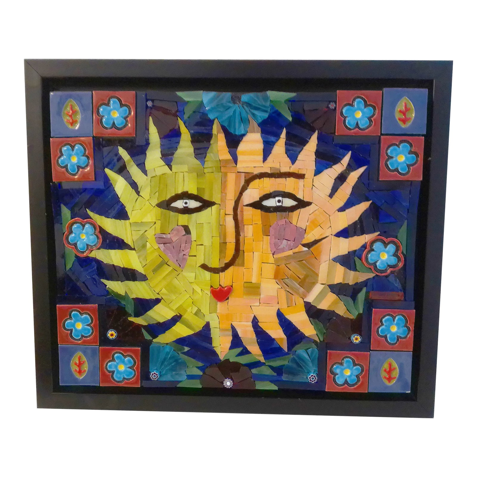Celestial Sun Mosaic Tile Wall Art: Charming mosaic piece depicting a happy sun in vibrant multi-color shades. Tile pieces are mounted on a black, block wood board installed on a black metal frame. Hardware on back for hanging. Artist