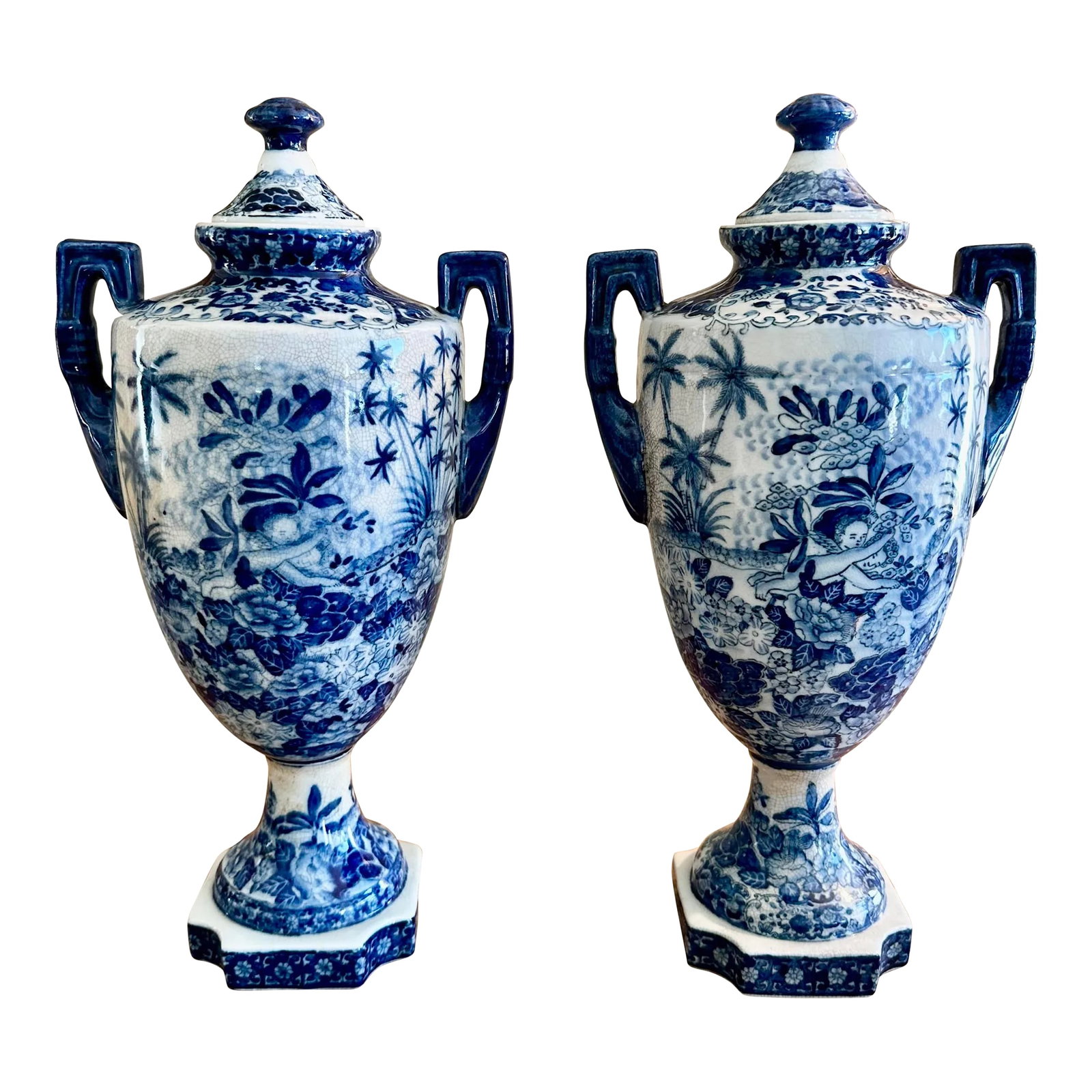 Vintage Pair of Chinoiserie Blue & White Craquelure Porcelain Lidded Amphora Urn Vases: This vintage pair of Chinese Chinoiserie blue and white Craquelure porcelain lidded Amphora vases is a beautiful addition to any collection. The intricate foliage design with angels and attention to
