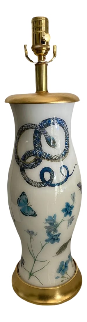 Eden Blue and White Table Lamp: Beautiful blues on soft white with gold gilt base and cap on this Eden serpent lamp. Classic blown glass shape adds to the romance of this witty botanical lamp. Clear silver cord and polished brass