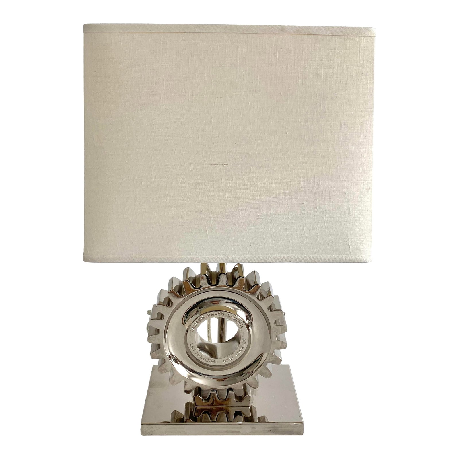 Vintage Ralph Lauren Chrome Gear Table Lamp: Vintage Ralph Lauren chromed metal industrial gear lamp with white linen shade. Logo displayed on the gear. Lamp dimensions to top of socket; 8" x 5.5"x 13.5"H. Please note that everything in my