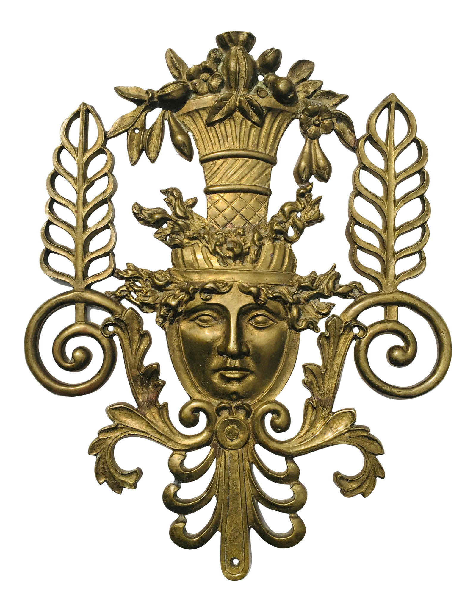 1980s Neoclassical Brass Wall Decoration: This solid brass decoration features stylized palm fronds, basket of flowers, Foliate motifs and the head of a goddess The height is 17.25 inches Width 14 inches Use as a decorative element or as an a