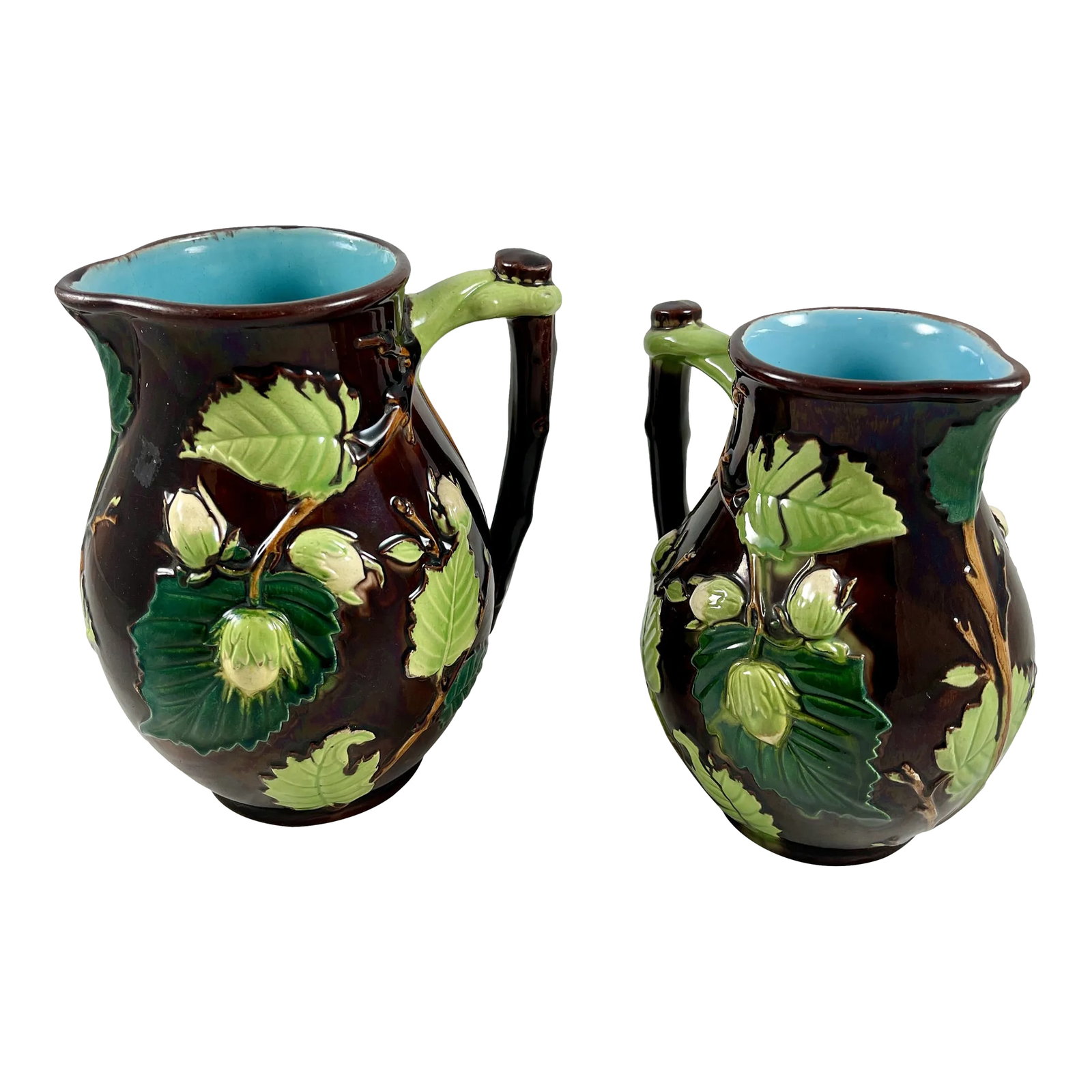 English Minton Aesthetic Movement Majolica Nut, Leaf & Vine Pitchers, a Pair: Attributed to Minton pottery in Staffordshire, England, a scarce and unusual sized set of majolica glazed pitchers in the Palissy style, circa 1870s. The Aesthetic Period pitchers are molded with a