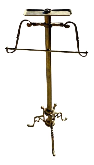Early 20th Century Turn of the Century Gentleman's Brass Valet: Elegant turn-of-the-century gentleman's brass valet. Compact hanger for coat and pull-out bar for pants with beautiful attention to design. A coin tray on top and decorative base and legs. Condition: