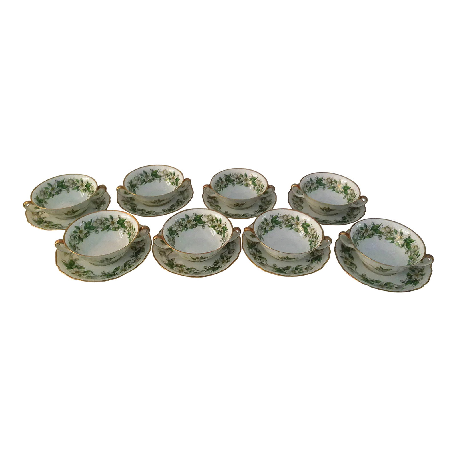 Mid-Century Hutschenreuther German Consume Bowls, Set of 8: Lovely set of eight Hutschenreuther Germany white porcelain consume bowls and saucers featuring a white and green floral motif with gold scalloped rims and handles. Marked "hutschenreuther Nohenberg