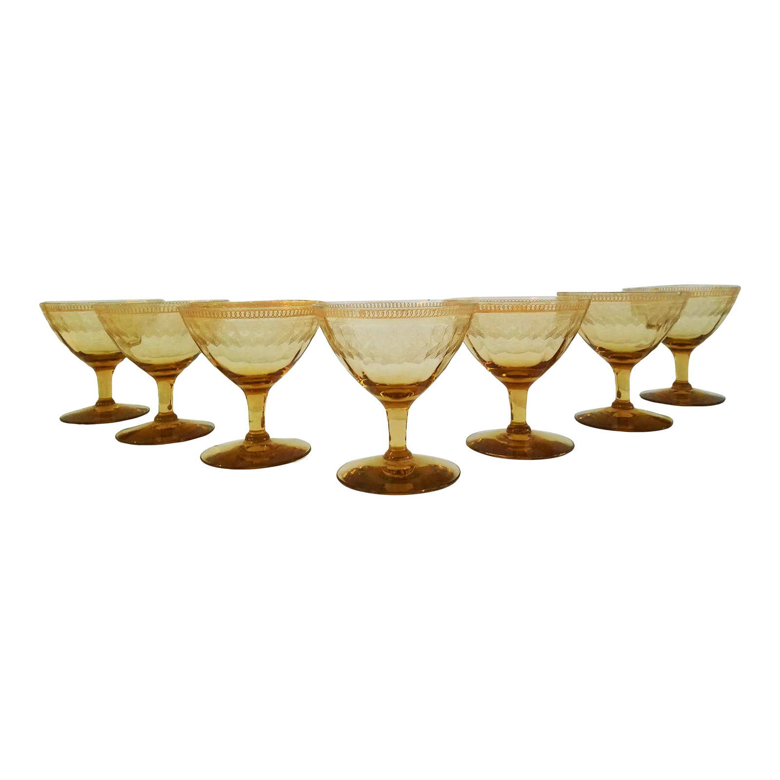 Mid-Century Amber Etched Optic Glass Coupes, Set of 7: Beautiful set of seven mid-century amber optic glass coupes featuring an ornate etched design around top perimeter of glass with gold accents. No maker's mark. Condition: Alterations: Original