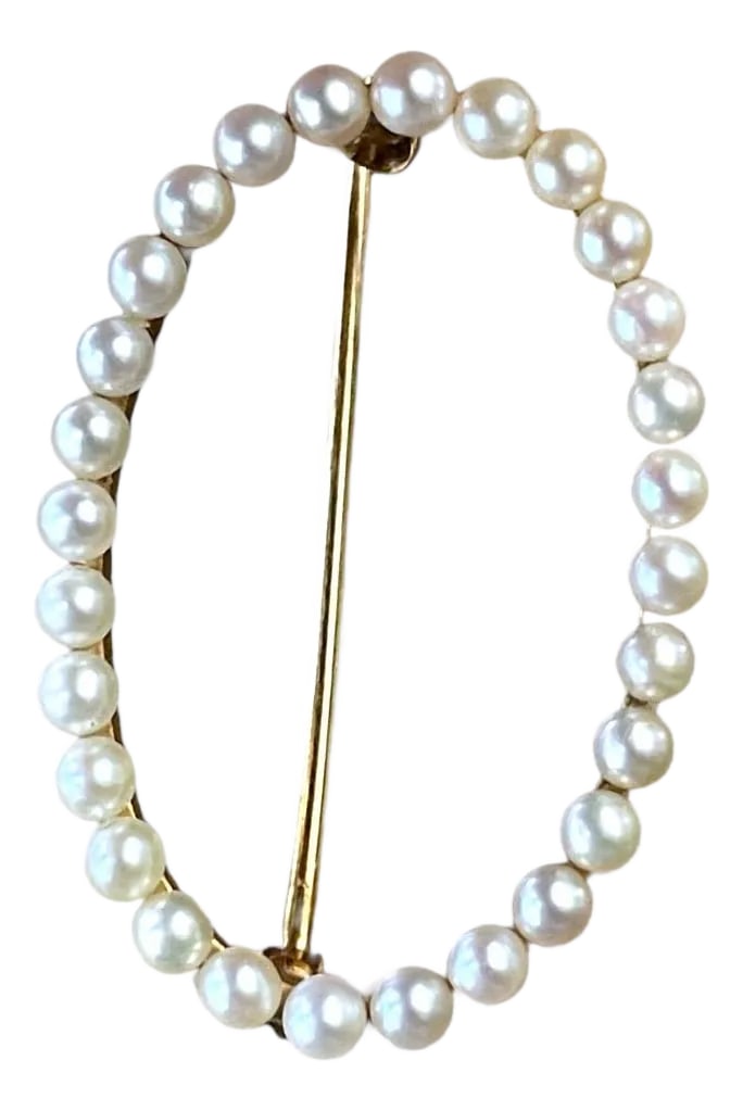 18th Century Estate Oval Pearl Pin in Yellow Gold: An elegant brooch featuring a delicate arrangement of lustrous pearls, set in a graceful oval shape. The pearls are meticulously aligned along a slender gold frame, creating a refined and