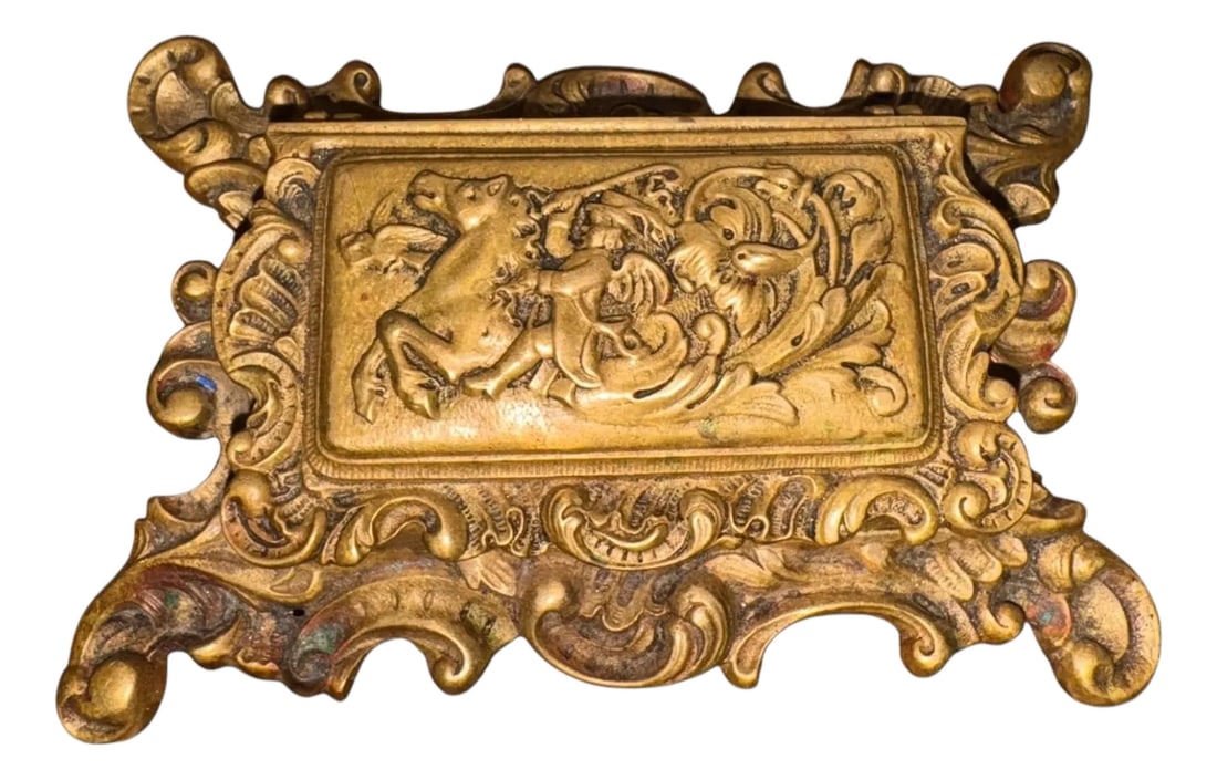 19th C. Bronze Rococo Stamp Box With Mythical Hippocampus & Cherub Detailing: This stunning 19th century stamp box, cast in bronze, features an ornate and unusual portrait of a cherub riding a winged hippocampus, a mythical creature that has the upper body of a horse and the
