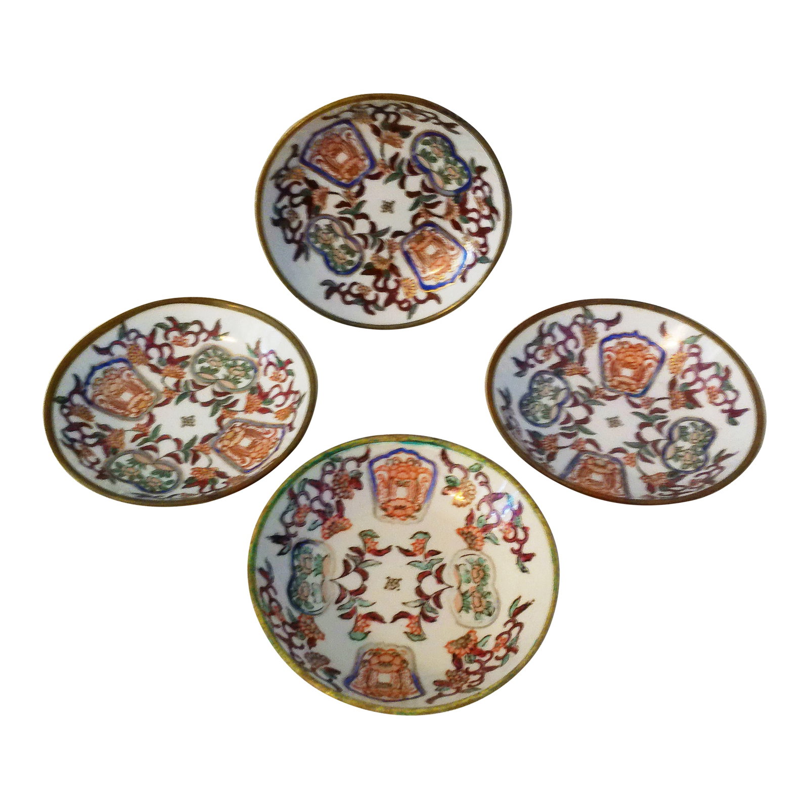 Mid-Century Chinese Brass Encased Porcelain Bowls, Set of 4: Lovely set of four mid-century brass encased decorative porcelain bowls featuring a hand-painted ornate motif on white porcelain with gold accents. One bowl has hardware on back should desire to displ