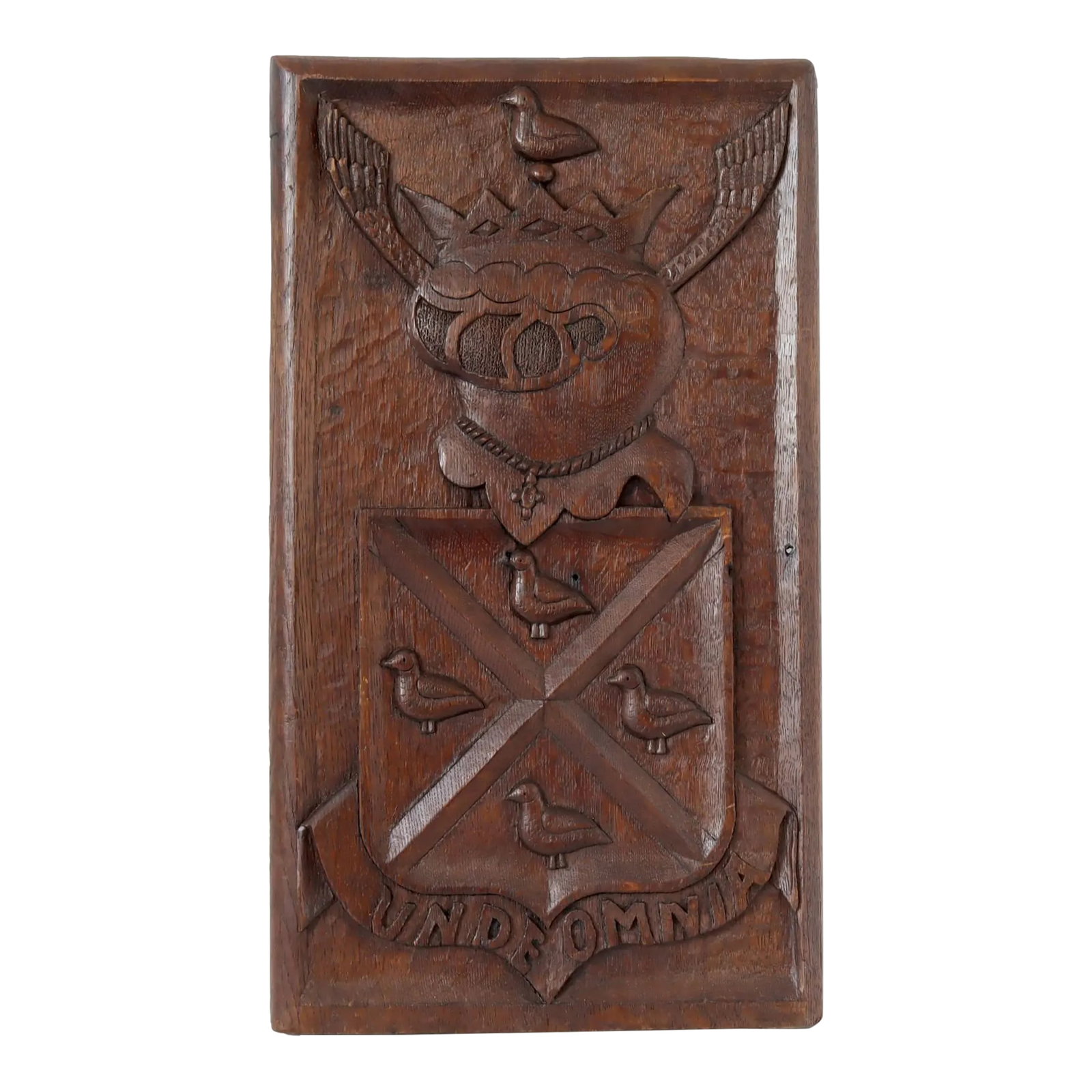 Antique Carved Heraldic Wall Panel: This antique carved wood wall panel features a meticulously detailed heraldic crest with a shield adorned by birds and crowned with a winged heart. The Latin motto "UNDE OMNIA," meaning "From Which