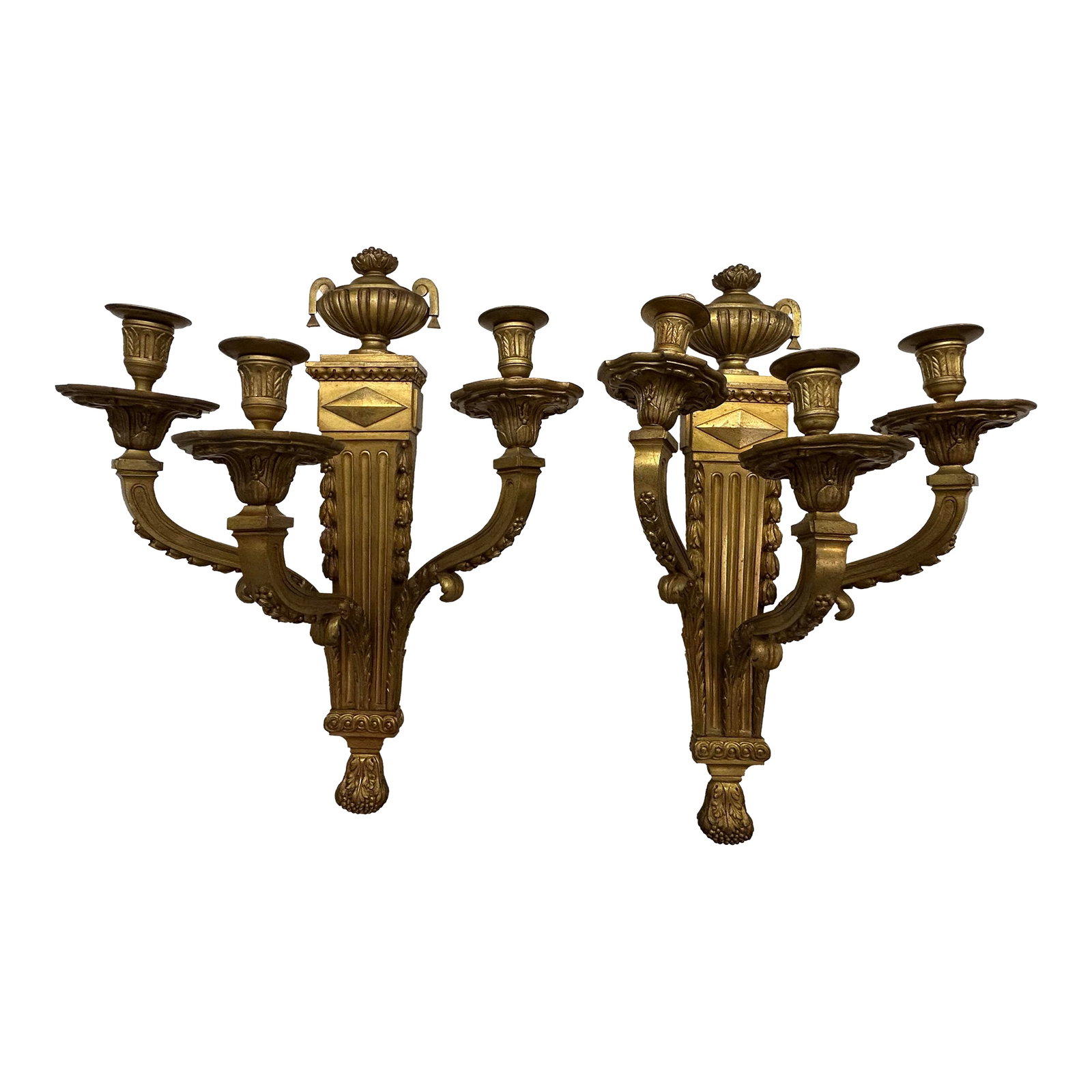 A Pair of Early 20th Century Bronze Candle Holder Wall Sconces: Neoclassical large ornate candle sconces. Early 20th century. The sconce features include 3 arms and bobeches decorated with floral motifs and an urn on the top. It mounts flush to the wall. Has