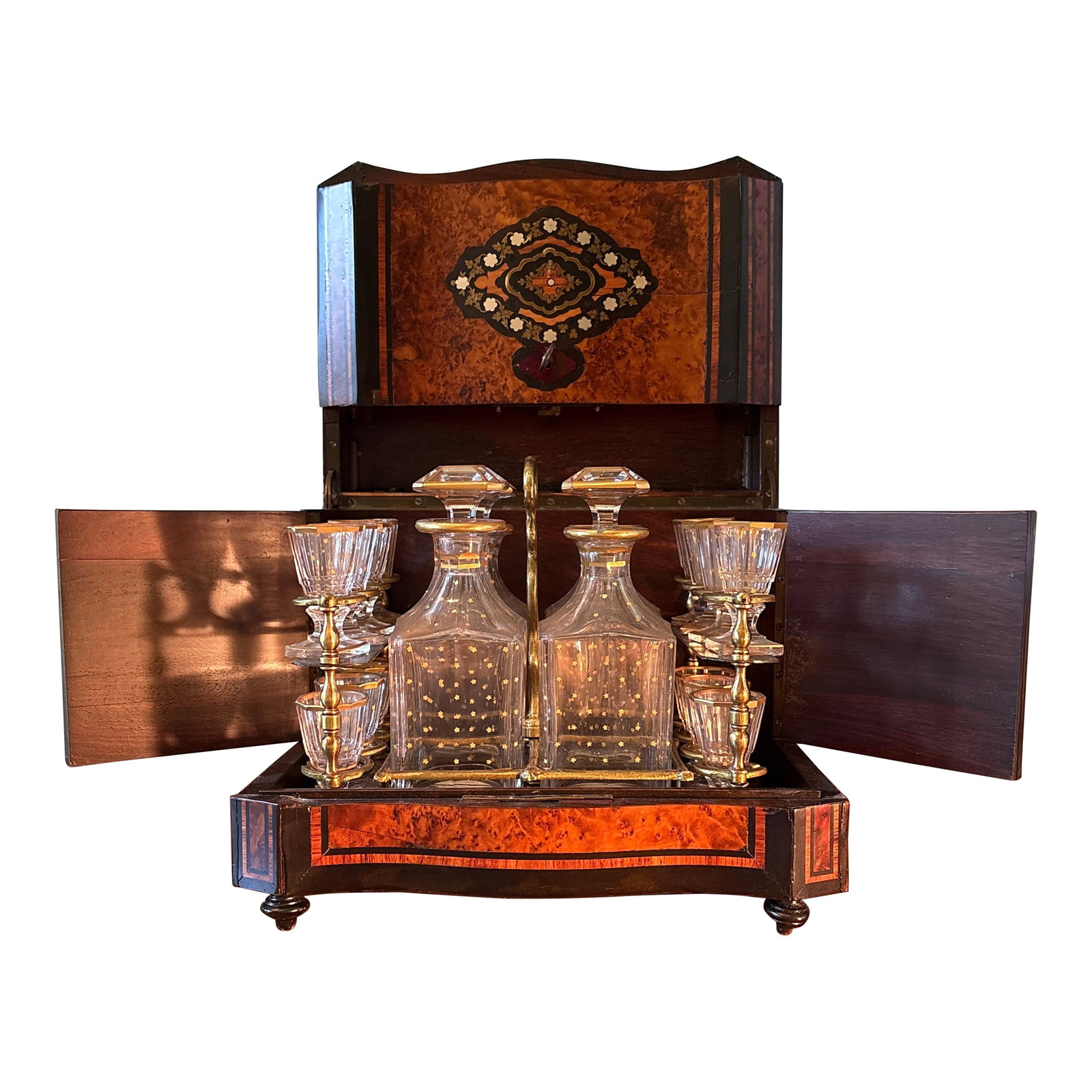 Antique Napoleon III French Liquor Cabinet: A lovely Napoleon III liquor cabinet with burlwood case with inlaid mother of pearl and brass detailing. The set includes- 1 burlwood case with hinged lid 4 glass decanters with 4 glass stoppers 16