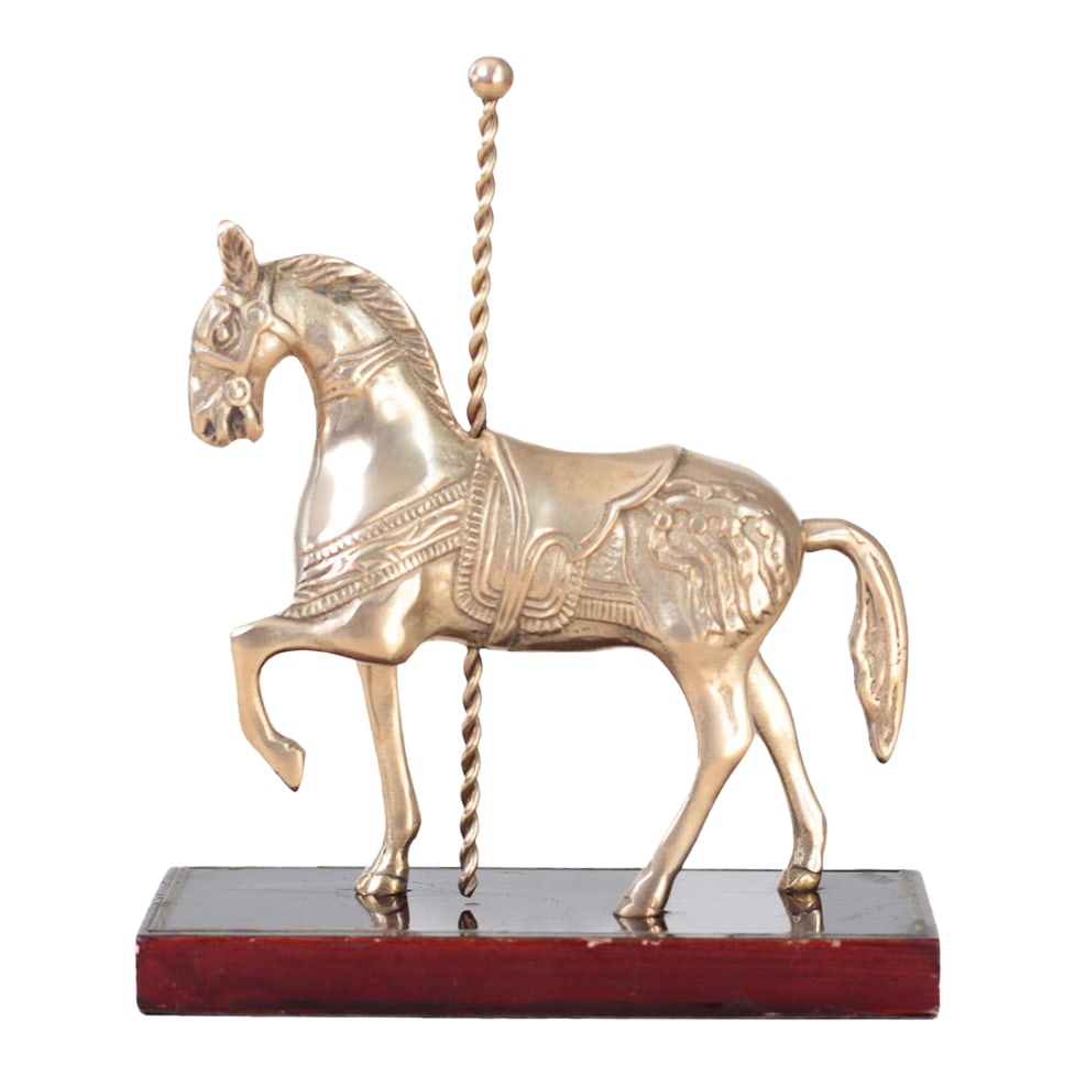 Mid-Century Brass Carousel Horse Figurine on Wood Base, Whimsical Home Decor: Vintage brass carousel horse figurine mounted on a polished wood base. Detailed saddle, twisted pole, and elegant prancing form evoke classic fairground charm. The warm brass finish contrasts beautifu