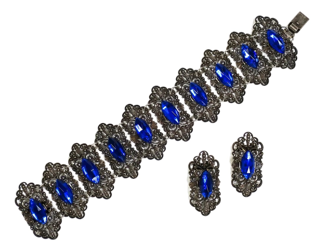 Antique Edwardian Sapphire Vauxhall Glass Bracelet Set 1910s: Antique Edwardian silver-plated link bracelet and clip-back earrings, 1910s. Long hexagonal links in an intricate openwork filigree set with marquise-cut sapphire Vauxhall glass stones. Plating is