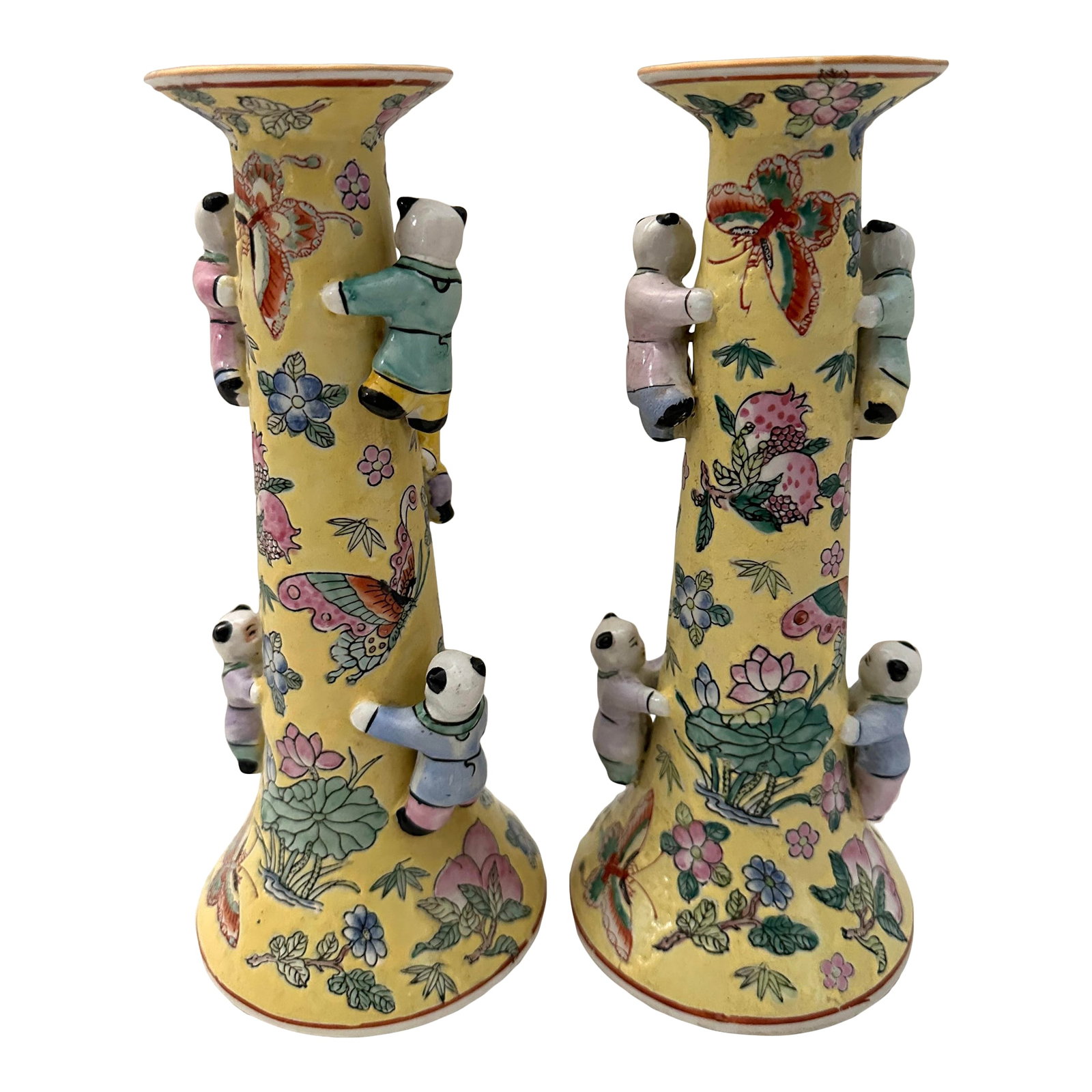 Pair of Chinese Fertility Candlestick Holders: Pair of Chinese Fertility Candlestick Holders. Vibrant yellow with soft pink, blue and green. Climbing children throughout with butterflies and foliage. 9.75in h x 4.25in base x 2.75in w top Make