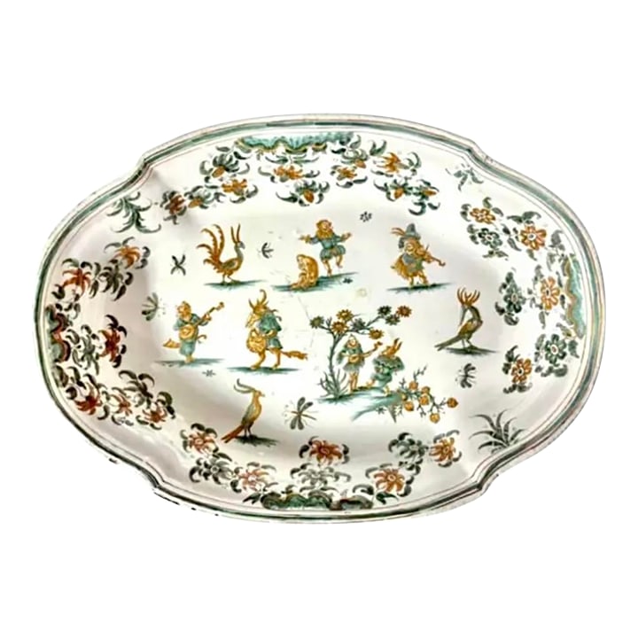 French Moustiers 18th Century Earthenware Serving Dish: 18th Century French (OLERYS-LAUGIER) Moustiers Faience Serving Dish with Grotesque Decor. Dish is hand-painted in the distinctive palette of ochre yellow and green on a creamy white background. The