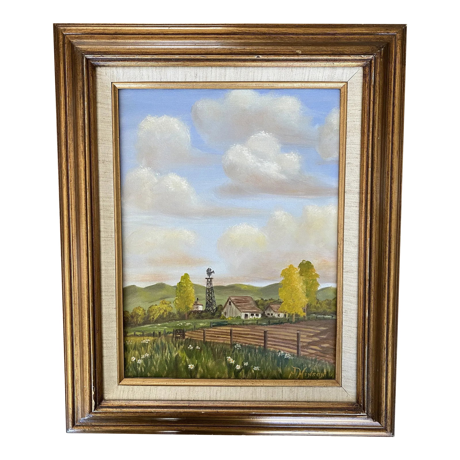 Framed Vintage Mid Century Painting of Farm Landscape: Mid century framed painting of farm landscape with farmhouse, field, and windmill and rolling clouded sky. Painting is framed with linen interior and brown and gold finish wood frame. Wire to hang is
