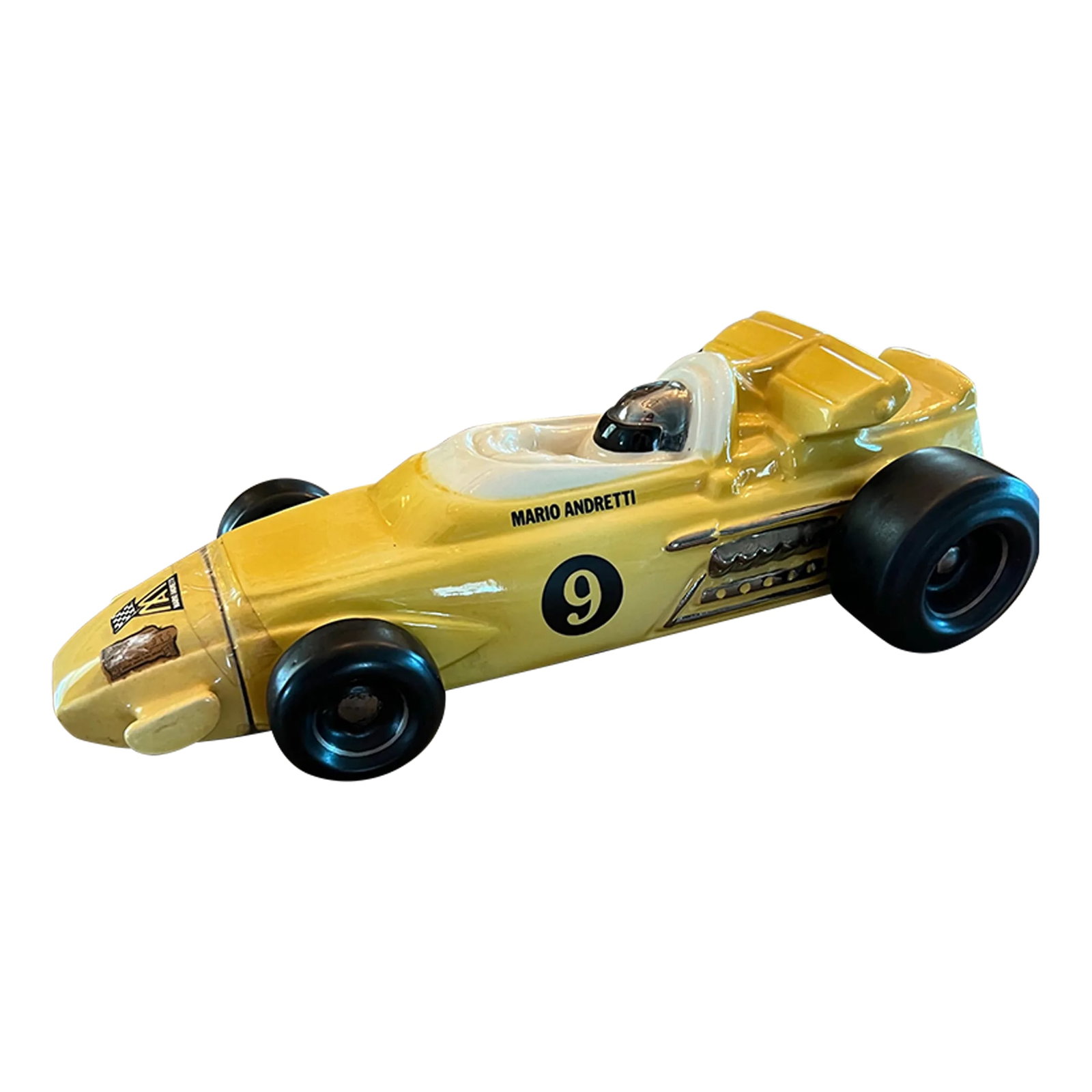 1970 Mario Andretti Indy Car Shaped Liquor Decanter: 1970 Bright yellow liquor decanter shaped like an Indy Car. The decanter was made by Royal Halburton China. Mario Andretti is painted on the side. Some of the liquor stamps are still attached. I did