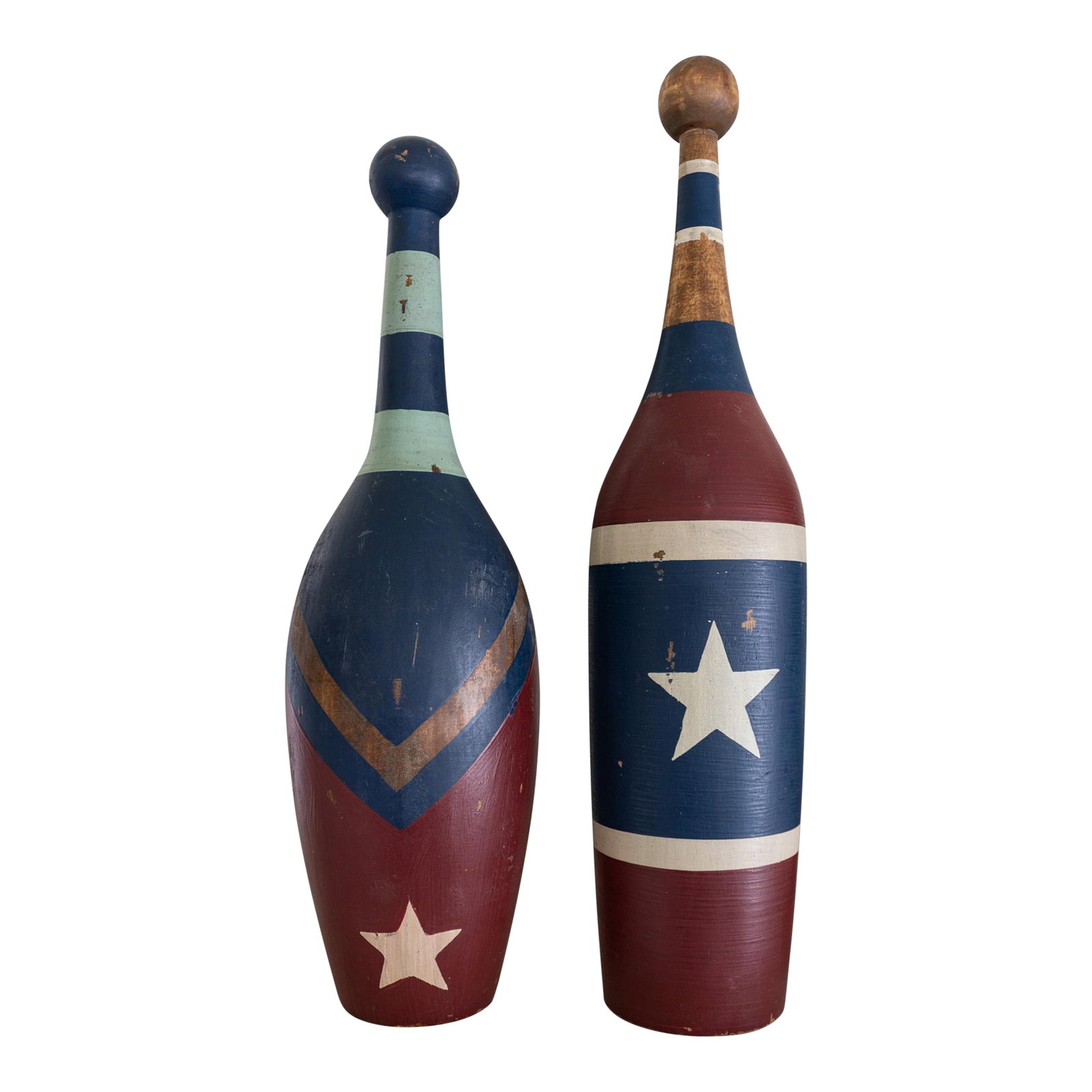 Pair of Early 20th Century Painted Circus Juggling Pins or Indian Clubs: A pair of early 20th-century circus juggling pins or Indian clubs, featuring solid, turned wood painted with red, white, and blue stars, stripes, and chevrons. A mint green accent in one club keeps