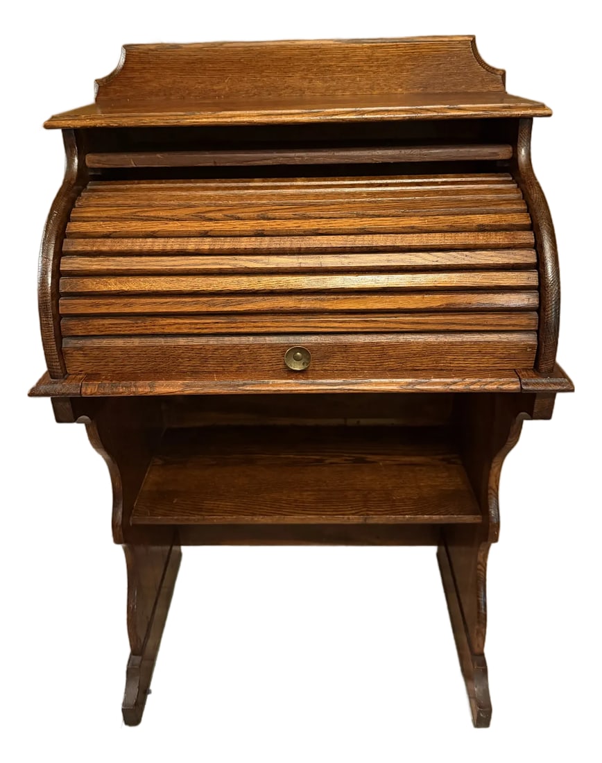 Antique Quarter Sawn Solid Oak Child's Roll Top Trestle Desk - Original Brass: Bring timeless warmth to a child's room or cozy nook with this antique child's roll top desk. Crafted from beautifully grained quarter sawn solid oak, this diminutive piece offers the full functionali