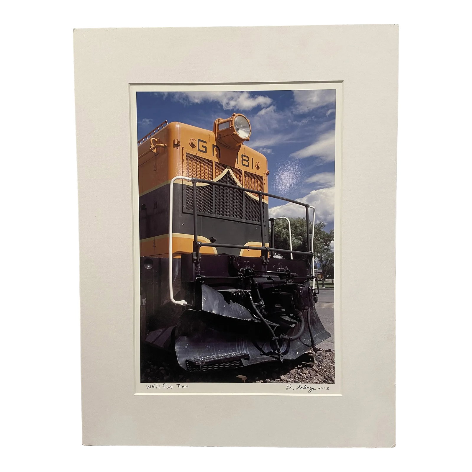 Yellow Train Photo - Whitefish, Montana by Vita Forlenza - Signed and Matted: Bold photo with bright pops of orange against a blue sky. Noted Bucks County, PA, photographer Vita Forlenza has traveled the world to build her portfolio of stunning images. She has participated in j