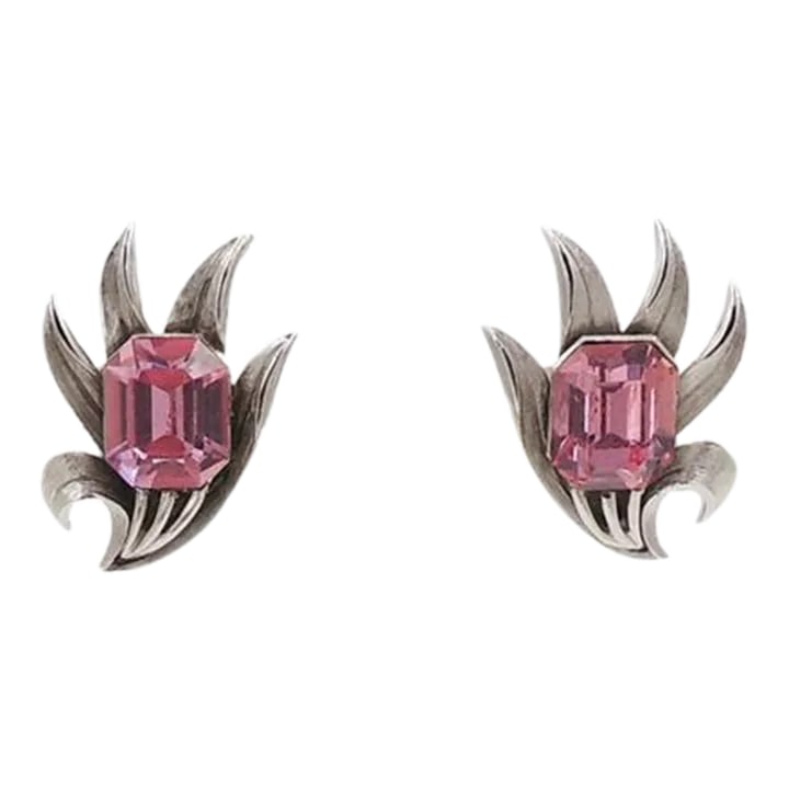 Vintage 1960s Signed Crown Trifari Faux-Pink Peridot Rhinestone Clip Earrings - 2 Pieces: This is part of Chairish's Costume Jewelry assortment. 1960s textured silvertone "fronds" with emerald cut faux-pink peridot rhinestone clip back earrings. Marked "Trifari." Measure: 1.25 inches L x 0