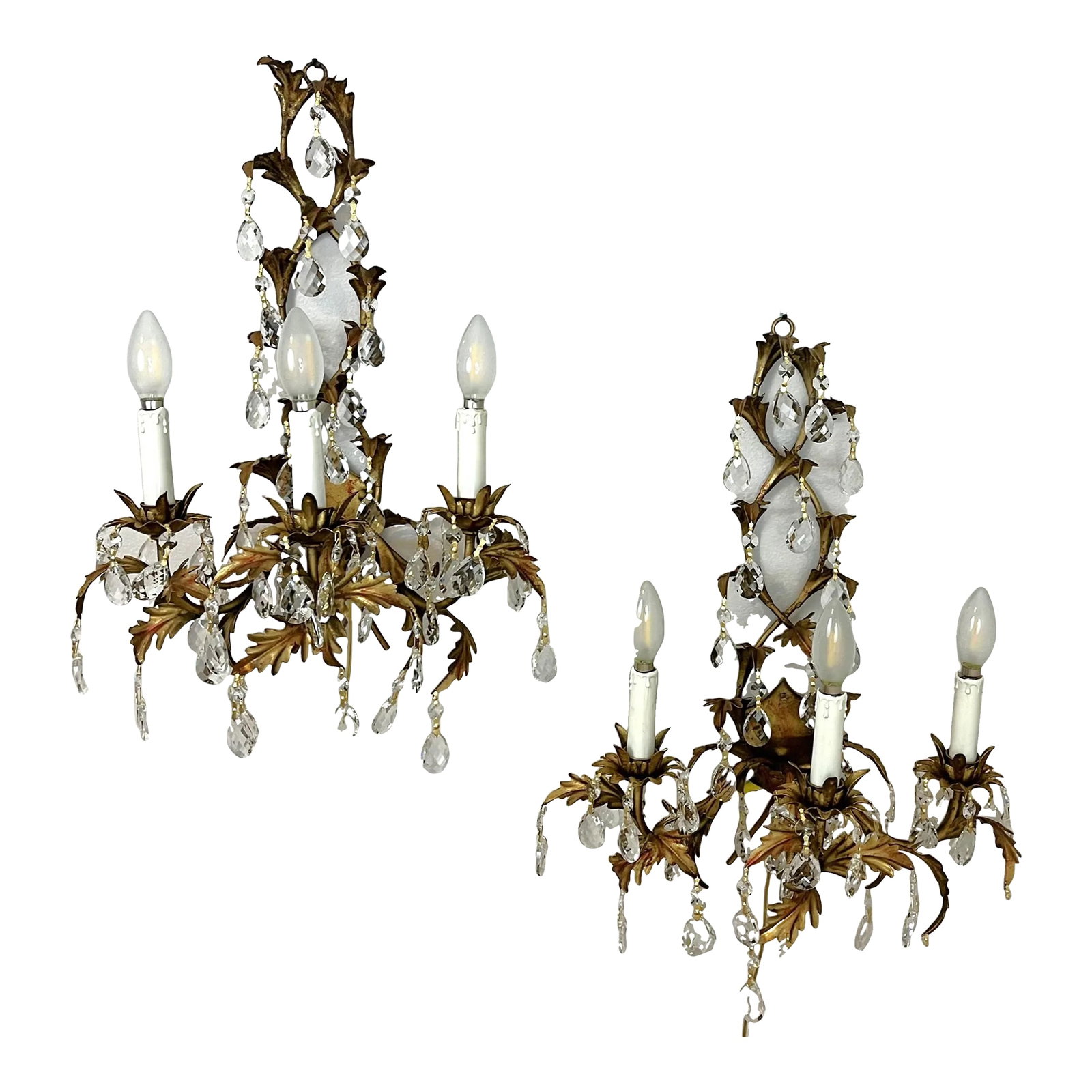 Mid Century Italian Tole Overflowing Crystal Wall Sconces- a Pair: Gorgeous pair of Italian tole and crystal wall sconces from the 1950's. Each has three candle holders with a cascading leaf design in a Hollywood Regency style. They are painted in a gold gilt look