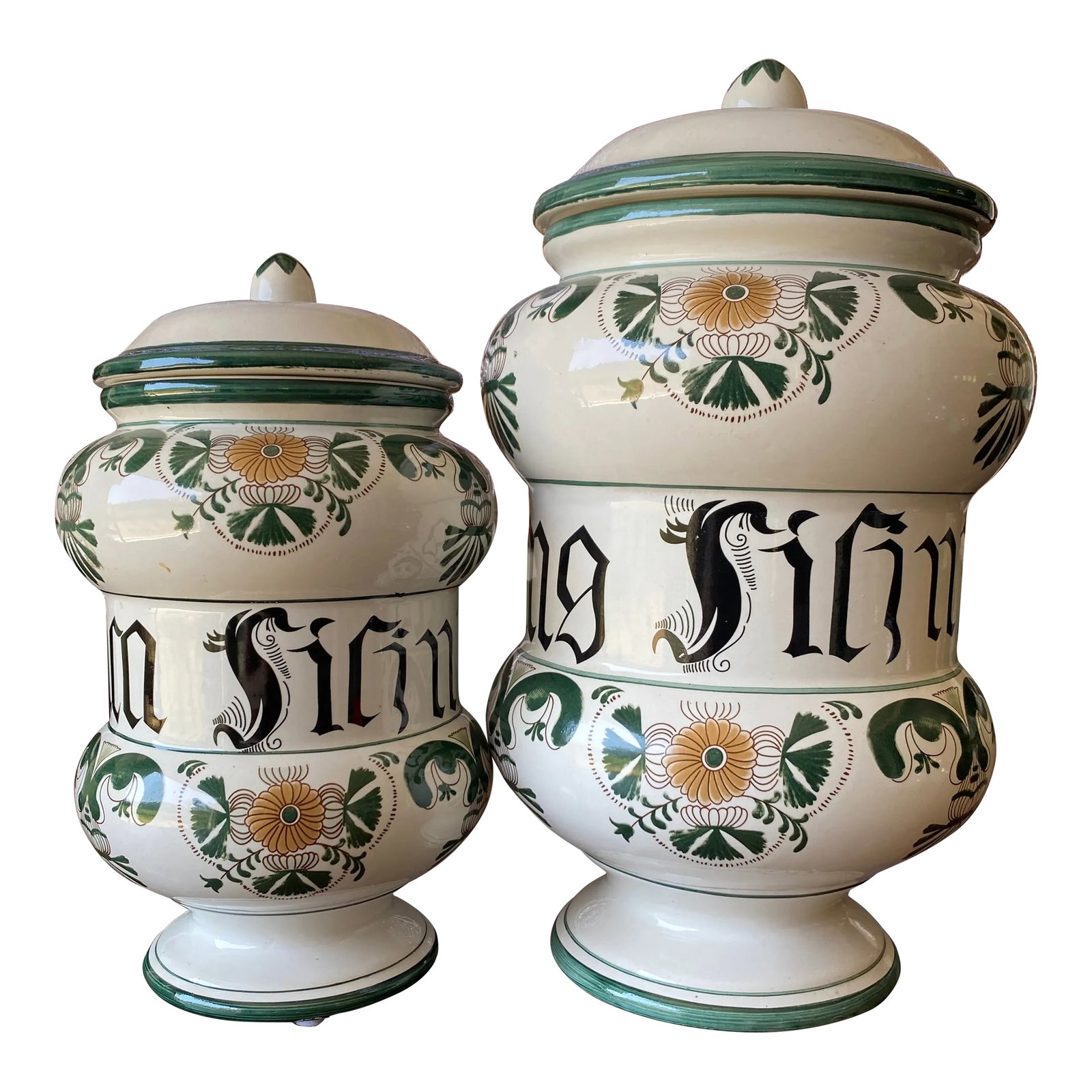 Set of Two 1900s European Apothecary Jars: Two lidded ceramic European apothecary jars with green, black, and tan paint. Good condition. Larger: 13.5" , approx. 11" tall and 6.5" wide Smaller: 11" , approx. 8.75" tall and 5" wide Condition: Al