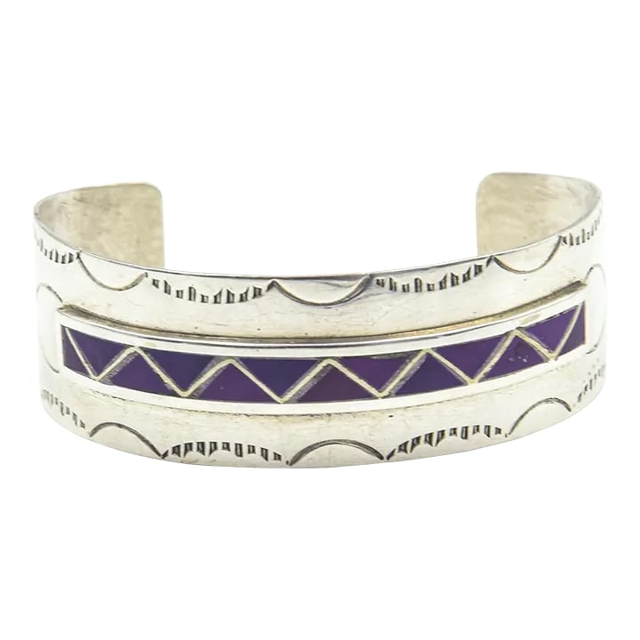 Late 20th Century Navajo Native American Inlay Sugilite Sterling Silver Cuff Bracelet by Mary Morgan: This is part of Chairish's Costume Jewelry assortment. Vintage Mary Morgan sterling silver cuff featuring a center line of inlay sugilite triangles. The top and bottom of the bracket has an etched