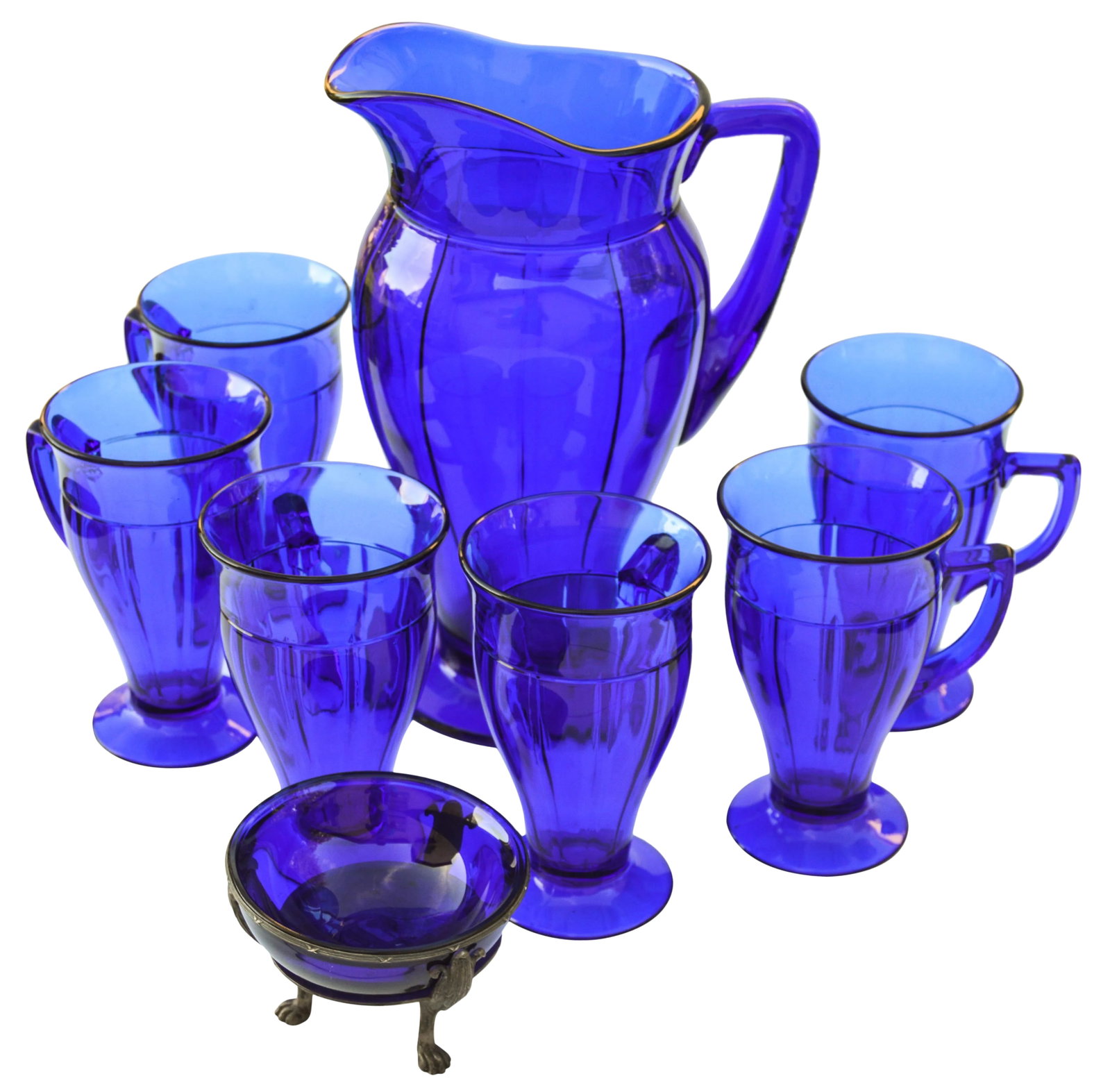Early 20th Century Mid-Century Blue Glass Set, S/8: Eight-piece set of vintage cobalt blue glassware with intricate designs. Set includes six glasses with handles, one pitcher, and one footed dish. Glasses: 4.25"L x 3.25"W x 5.25"H; pitcher: 7"L x 4.5"