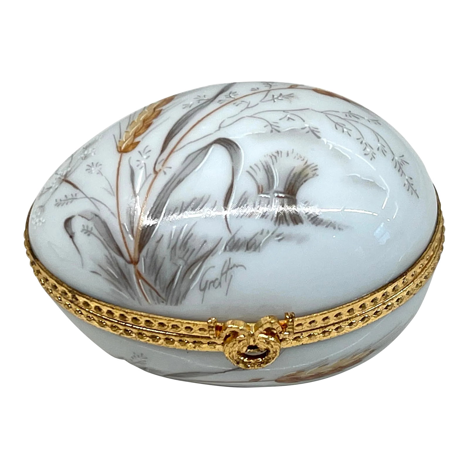 Early 20th Century Limoges Egg Shape Box: This charming artist signed Limoges box has been made in the form of an egg and sports a hand painted gold ear of rye motif. The exterior is a robin's egg white color. The box is finished with