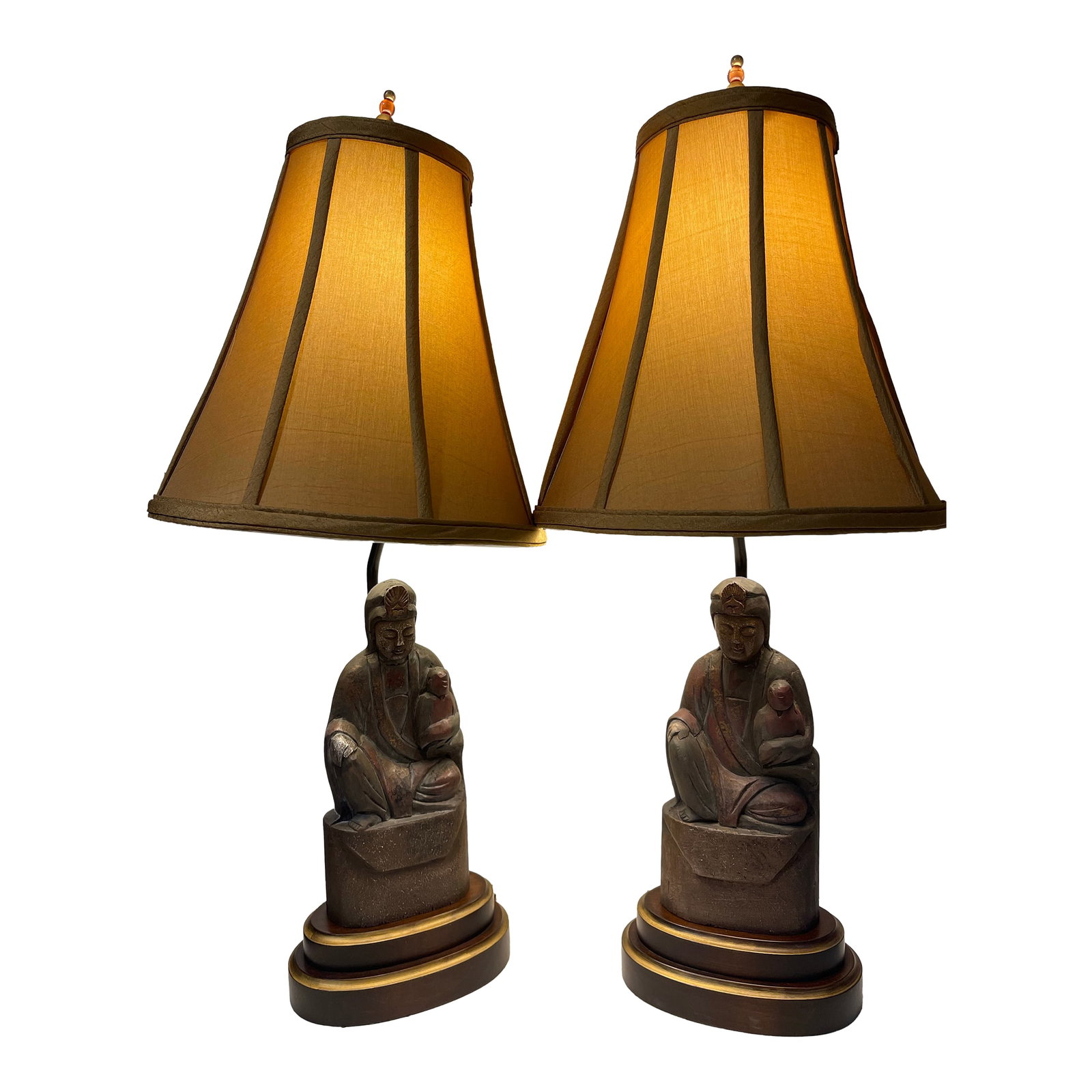 Frederick Cooper Guan Yin (Boddhisattva of Compassion) Statue Figurine Lamps - Set of 2: A beautiful and unique set of early Frederick Cooper Lamps. Features a pair of Buddhist statues holding a baby, with lovely round coral knotted top pieces, wooden rounded tiered platform base with
