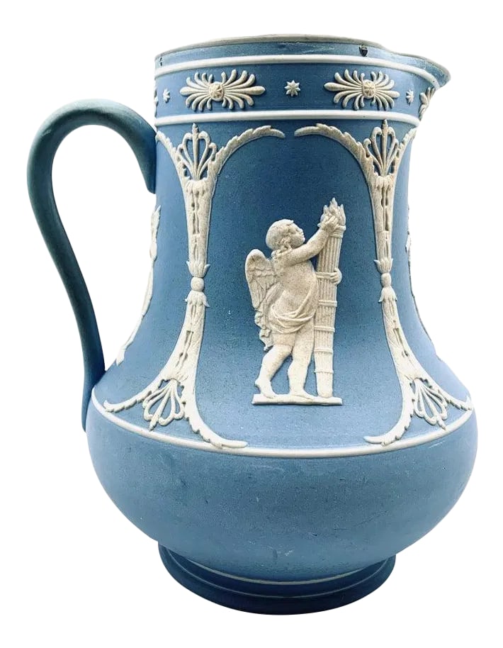 Dudson Jasperware Pitcher in Blue With Neo-Classical Motif-8.25" Tall: Dudson neo-classical pitcher in blue Jasperware. Decorated with sprig molded accents and cherub scenes. The interior is glazed. There is wear to the handle with some loss of color. The pewter top is