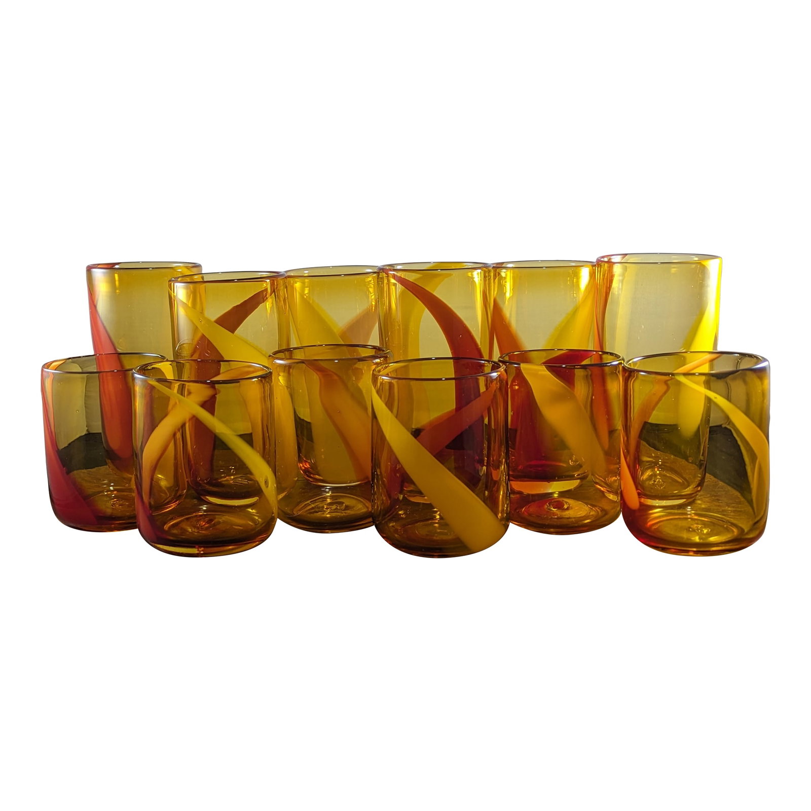 1990s Amber and Red Handblown Tumblers Set- 12 Pieces: This is a set of 1990s vintage handblown amber glass tumblers, swirled with red and yellow reminiscent of amberina. Each piece is made of heavy glass, with a few small air bubbles and pontil marks on
