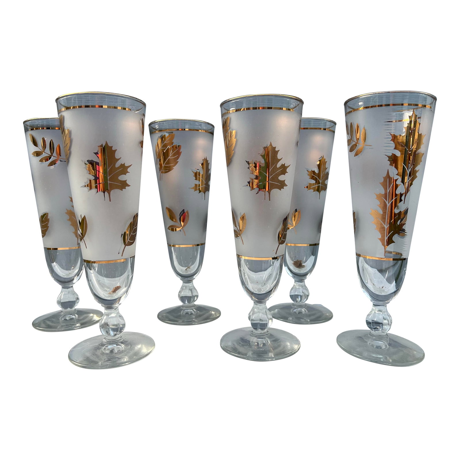 1950s Mid-Century Modern Libbey Golden Foliage Pilsner Glasses- Set of 6: 1950s Tall Vintage Libbey Golden Foliage Pilsner Glasses. These stemmed glasses have 22K gold leaf detailing fall foliage leaves. The tall glasses have a decorative glass bulb on the stem. The golden