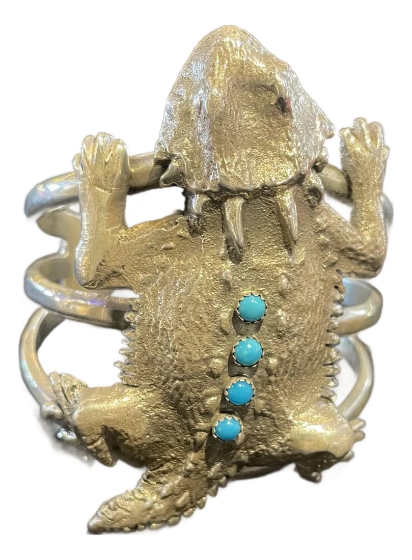 Navajo Robbie Mauelito Horned Toad Sterling Silver Cuff Inlaid Turquoise: Navajo sterling silver cuff by Robbie Manuelito Tufa casting with sleeping beauty turquoise 6-7 inch wrist Toad measures 3.25 inches long x 2.25 wide Written appraisal Condition: Imperfections: No