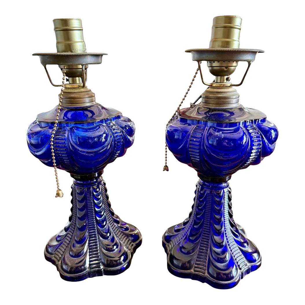Late 19th Century Pair Cobalt Blue Coolidge Drape Oil Lamps-Converted Electric-Victorian Table: This pair of cobalt blue Coolidge drape oil lamps reflects the bold glasswork favored in American interiors during the late Victorian period, circa 1890-1910. The dramatic draped and ribbed glass