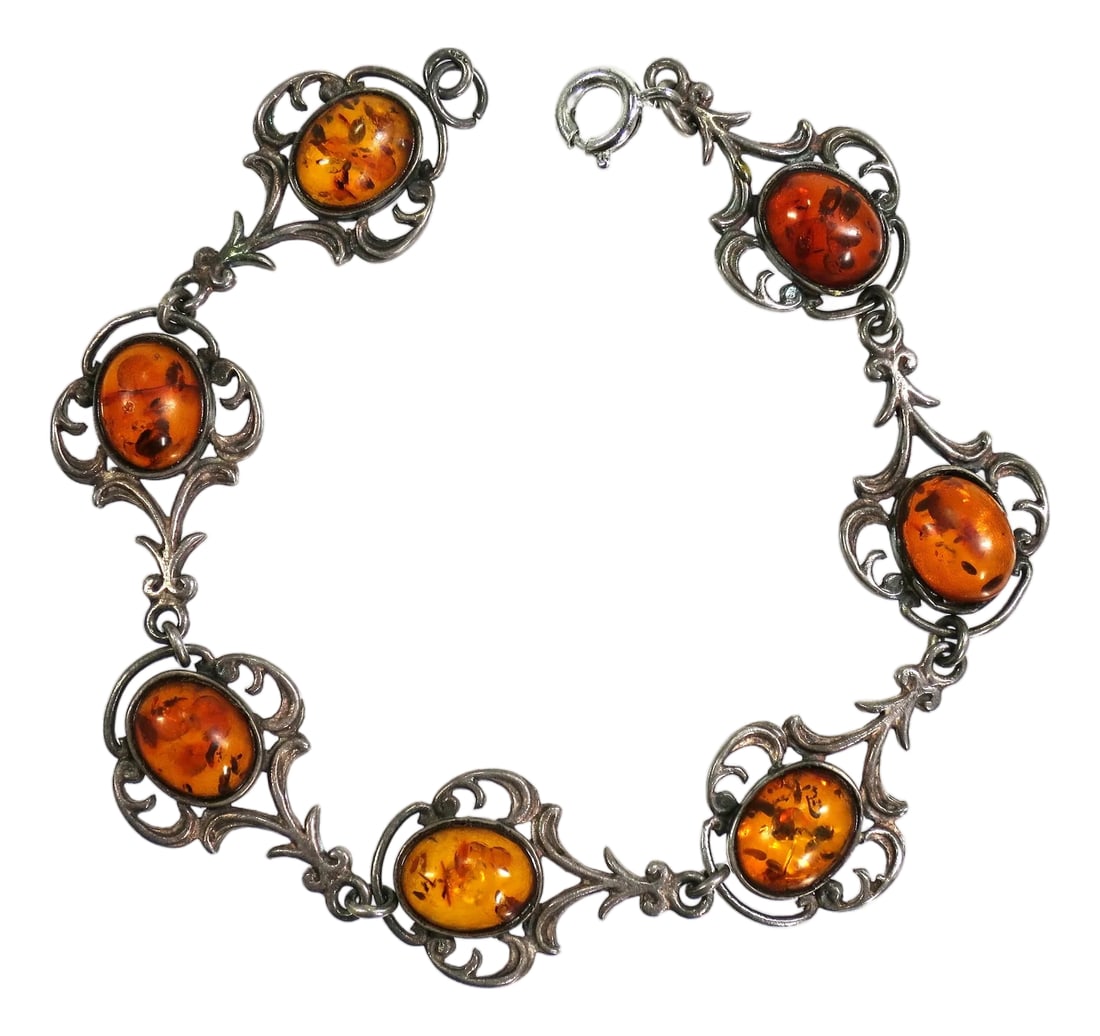 Antique Edwardian Sterling Amber Bracelet 1900s: Antique Edwardian sterling and amber link bracelet 1900s. Openwork links in a flowing design feature open-back bezel-set oval cabochons of warm amber with multiple inclusions. The silver has a warm pa