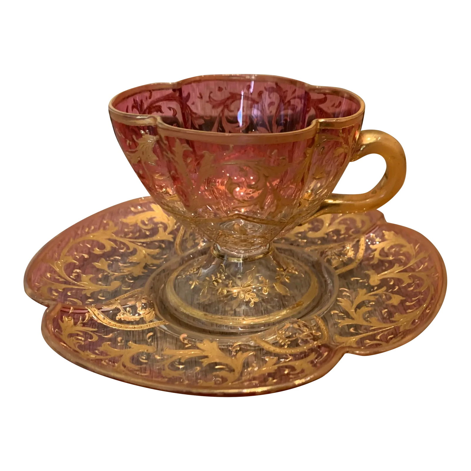 Vintage Eastern European Ombre Glass Cup and Saucer Set- 2 Pieces: Eastern European ombre glass cup and saucer. The rose colored set is a subtle clover shape and heavily embellished with gold scrollwork. Cup 3.25w x 2.5 d x 2.5 tall Saucer 5 x 5 x 1/4 Condition: Alte