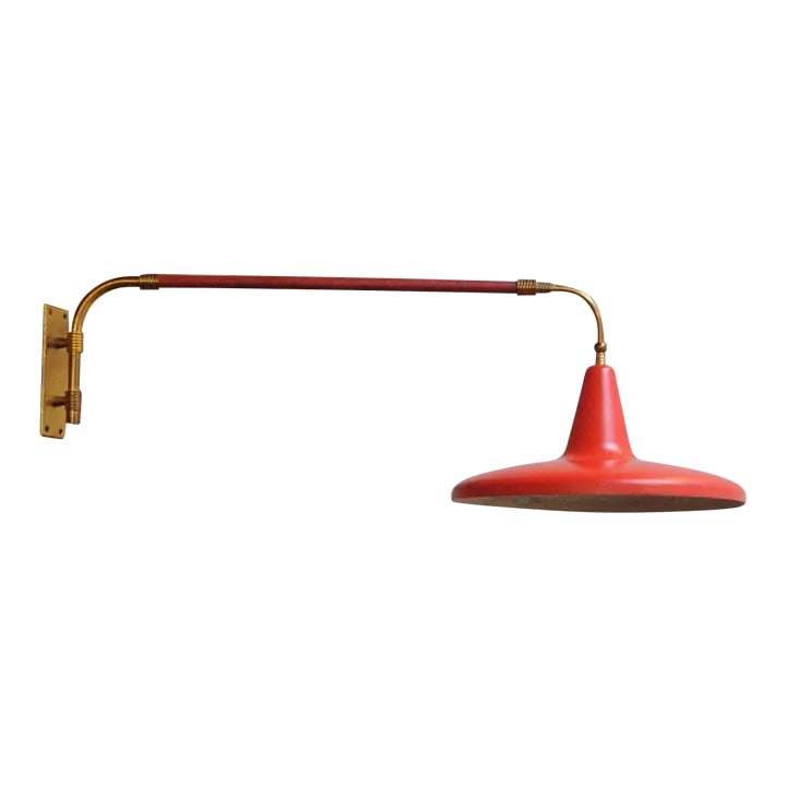 Mid Century Italian Modernist Wall Swag Lamp in Brass and Red Lacquered Metal: Extendable, elegant swag lamp in brass with perforated red lacquered metal shade and red leatherette wrapped arm and handle containing the on/off switch (Italy, ca. 1950s). The handle is counter weigh