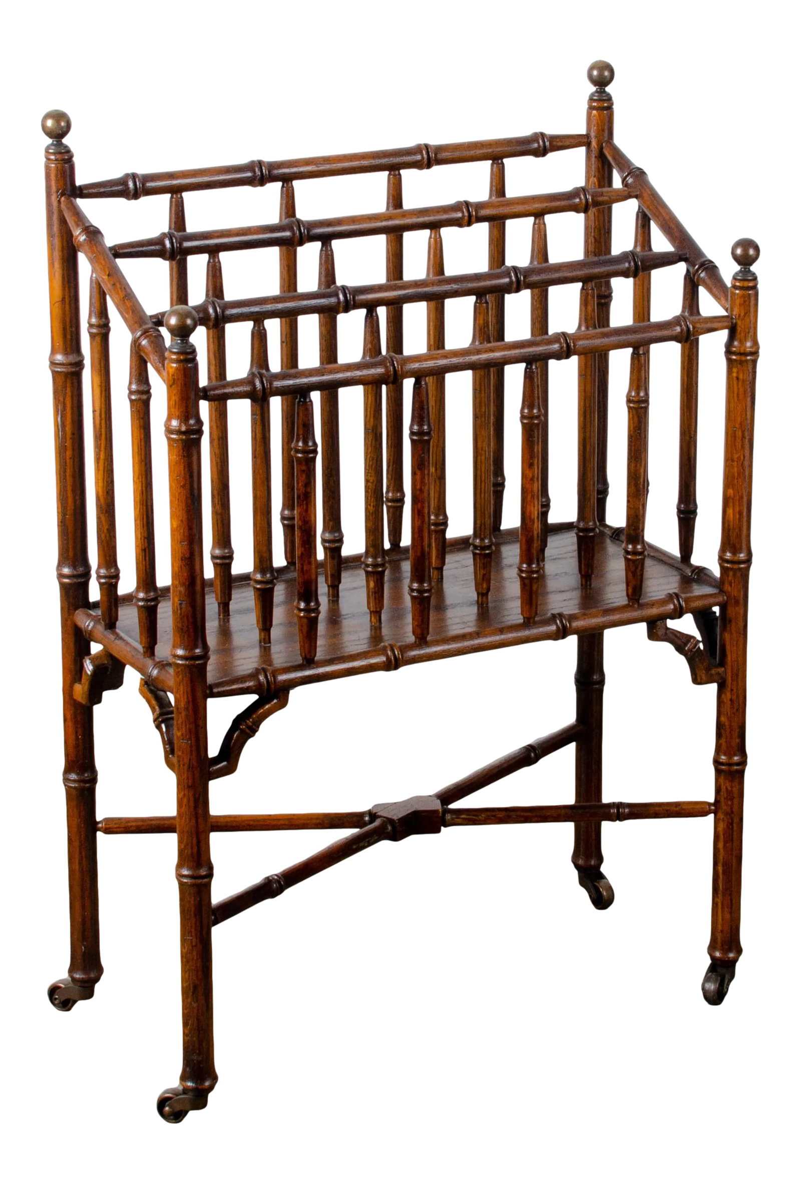 Faux Bamboo Canterbury Magazine Rack: A vintage turned oak faux bamboo canterbury magazine rack with brass ball finials and casters, circa 1950s. 21 inches wide by 10 1/2 inches deep by 30 1/2 inches tall Condition: Alterations: Original