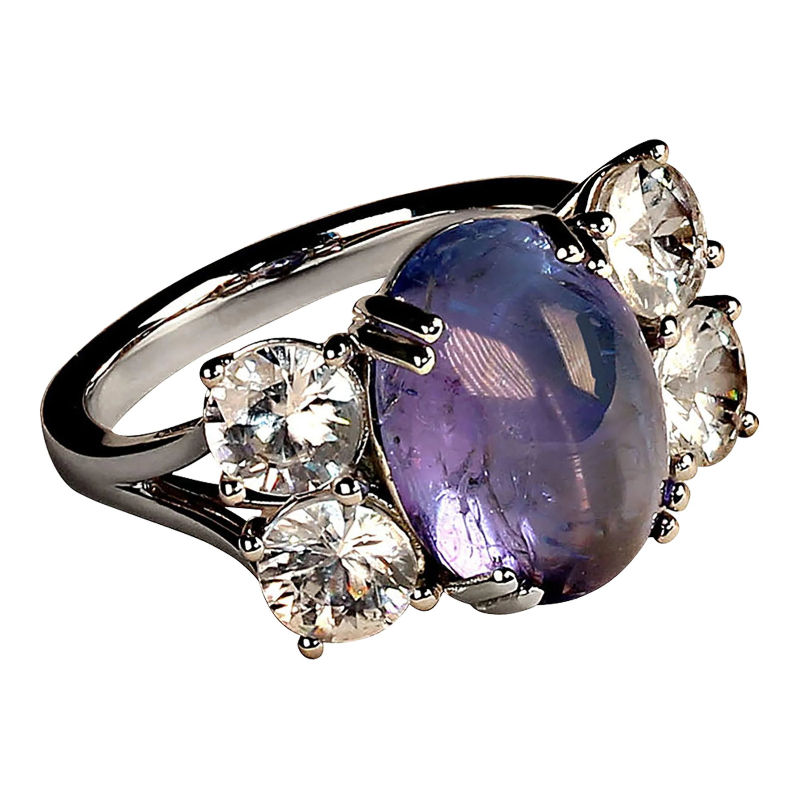 Dinner Ring of Cabochon Tanzanite and Sparkling Genuine Zircons Size 6.75: Gorgeous dinner featuring a clean sparkling blue-purply oval Tanzanite cabochon enhanced by two pairs of glittering colorless genuine Zircons. This stunning flashing ring will delight wherever it