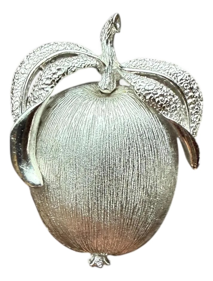 1960s Sarah Coventry Silver Brooch"Adam's Delight" Collection: Offering a vintage Sarah Coventry apple brooch, from the "Adam's Delight" collection released in 1961. Silver-tone Metal featuring a textured or Florentine finish on the main body of the apple and