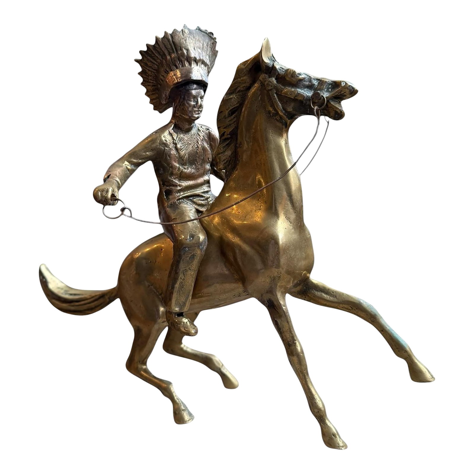 1960s Brass Sculpture Native American Chief Running Horse Figurine: Offering a vintage brass sculpture of a Native American chief riding a horse capturing an action fast running display. The rider leans right with headdress tilting left and horse nearly rearing with