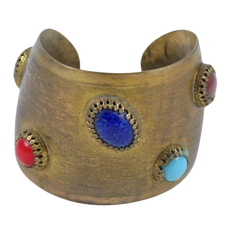 1950s Exotic Cuff: This is part of Chairish's Costume Jewelry assortment. Antique brass finished cuff adorned with faux semi precious cabochon stones. Condition: Alterations: Original Condition Unaltered Imperfections: