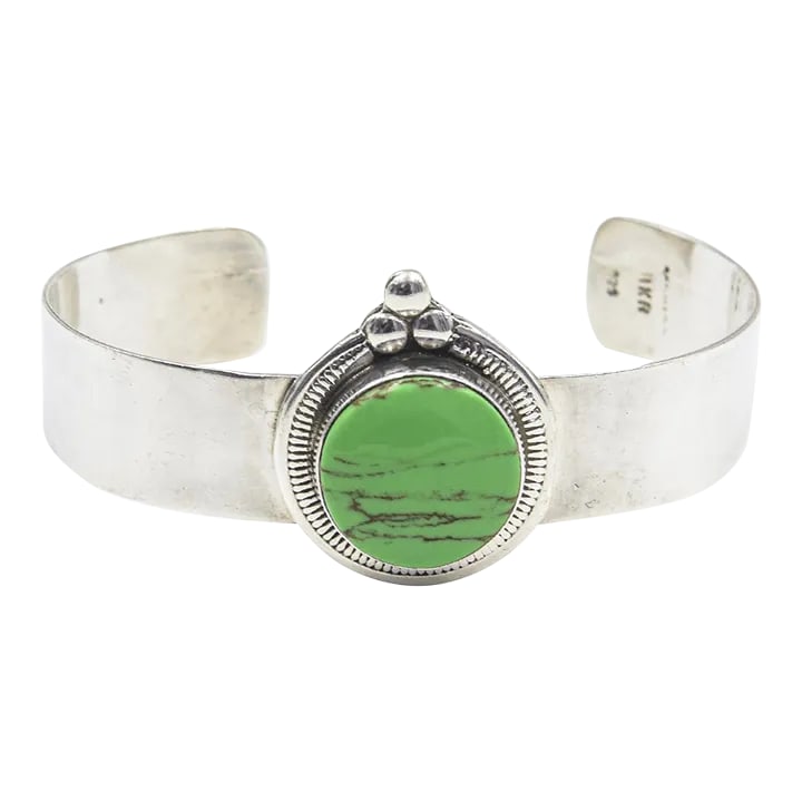Late 20th Century Mexican Green Gaspeite Sterling Silver Cuff Bracelet: Vintage Mexican sterling silver cuff bracelet featuring a bezel set round green cabochon gaspeite. Marked on the back 925. Interior of the cuff measures 6" with an additional 1 1/4 " gap for a total