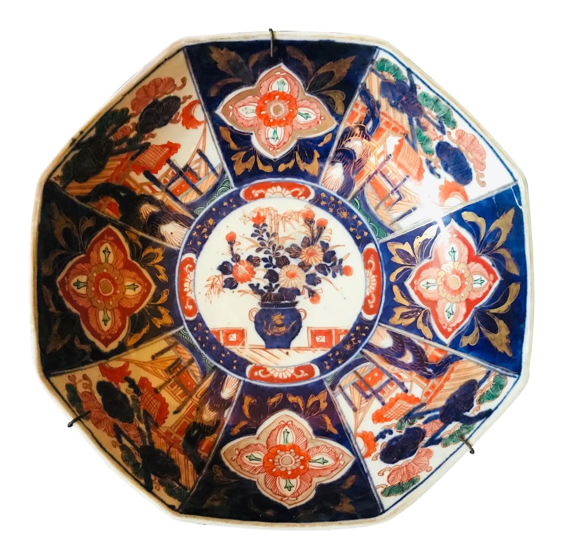 19th Century Meiji Period Japanese Imari Bowl: This large, distinctive, octagonal porcelain Imari bowl is painted in rich, inky blue, copper, orange, red and green. It's elegant, geometric structure focuses on an elaborate floral arrangement